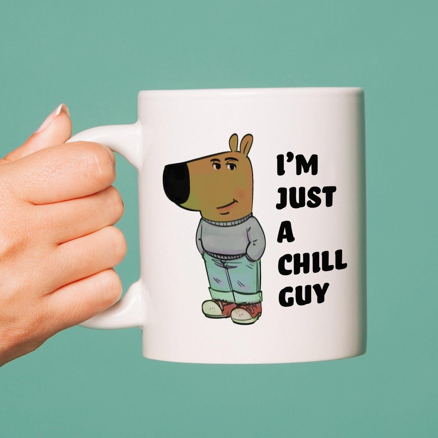 Mug with cartoon dog and text 'I'm just a chill guy' held by a hand against a teal background