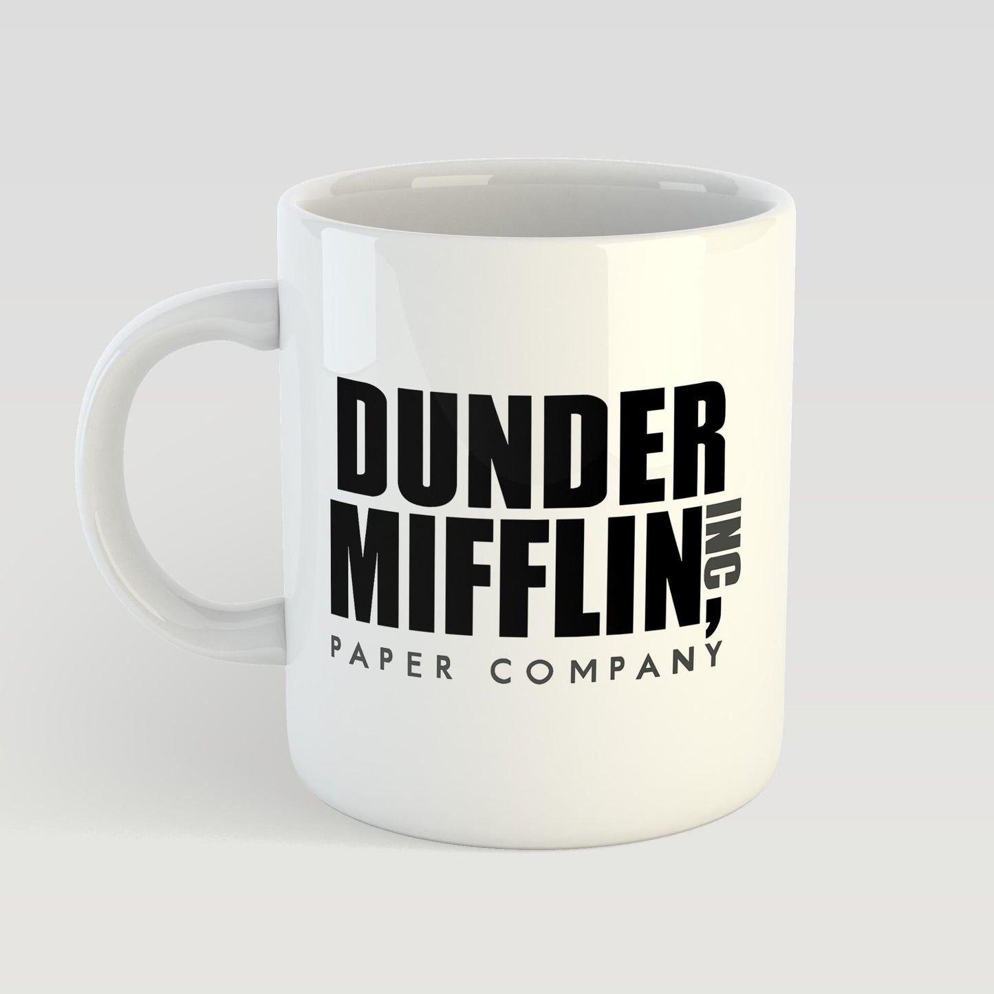 White mug with 'Dunder Mifflin, Inc. Paper Company' text on a light gray background